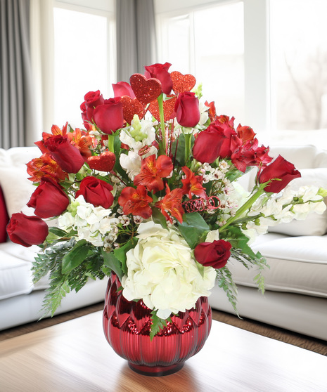 Luxury Valentine’s bouquet with red roses, hydrangea, lilies, and stock in a red mercury glass vase. A show-stopping gift for your sweetheart.