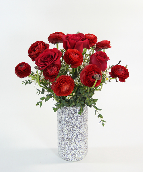 ranunculus blossoms with their delicate petals in a textured gold  vase creating a charming arrangement that's perfect for gracing any space with a touch of soft beauty.