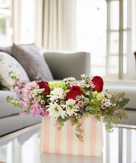 Luxurious Valentine’s bouquet in a pink-and-white striped ceramic purse with hydrangea, stock, chrysanthemums, and daisy poms