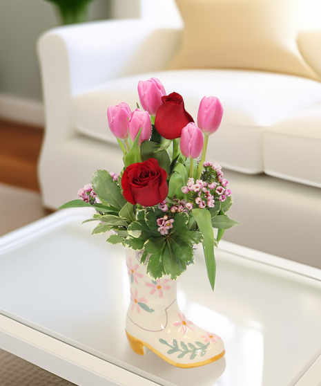 Tulips and wax flower in a ceramic floral cowboy boot. A sweet and charming arrangement that makes a delightful gift for any occasion.