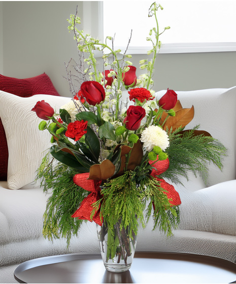 Luxury holiday bouquet with evergreens, magnolia, red & white blooms, icy branches & metallic ribbon. Elegant, festive winter design.