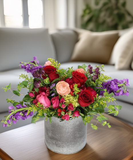European Splendor bouquet with roses, ranunculus & stock in a corrugated metal vase. Elegant low-lush floral gift with a wildflower aesthetic