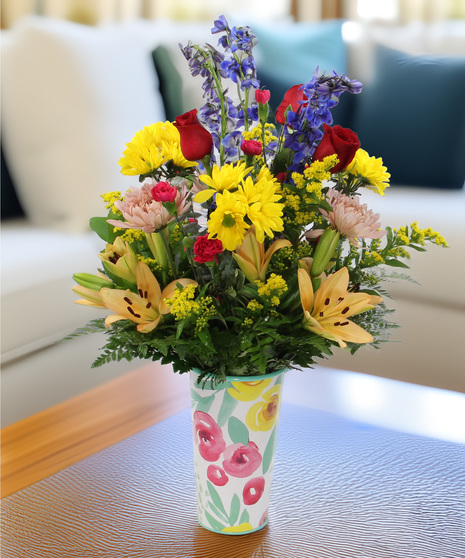 Fascination bouquet with delphinium, daisies & lilies in fall-toned vases. Perfect spring floral gift for any occasion