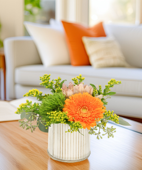 A petite bouquet featuring a mini gerbera daisies, moss carnation, daisies and accents in a ceramic pot that brings a playful pop of color to any space.