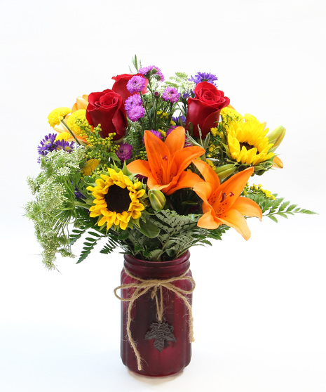 This charming ensemble features the cheerful glow of sunflowers and the timeless elegance of Asiatic lilies, all lovingly nestled in a rustic vase. 
