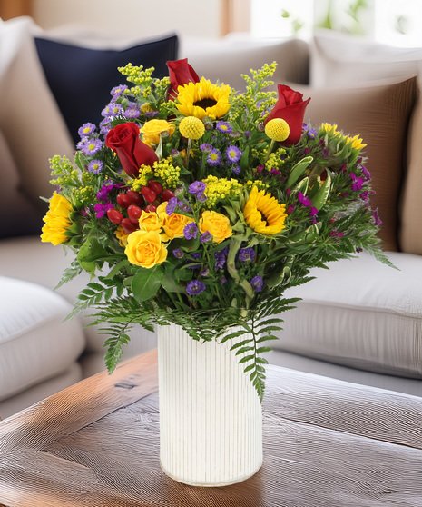 This bright design features sunflowers and spray roses with a mix of seasonal flowers in a white-washed corrugated tin. The bouquet has a rustic look that feels fresh