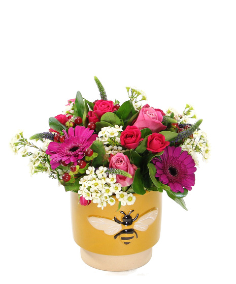 Brighten someone's day with this bouquet featuring a cheerful mix of spray roses and mini gerbera daisies with accents in a charming ceramic pot adorned with a bee