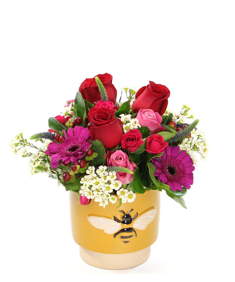Brighten someone's day with this bouquet featuring a cheerful mix of spray roses and mini gerbera daisies with accents in a charming ceramic pot adorned with a bee