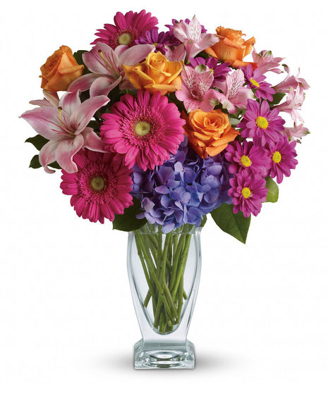 This versatile mix includes blue hydrangea, orange roses, light pink Asiatic lilies, pink alstroemeria, hot pink gerberas and purple daisies with a bit of rich green salal.