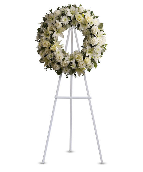 Ethereal white blossoms set among a ring of soothing greens form a classic wreath certain to evoke the pure heart and gentle spirit of a loved one 