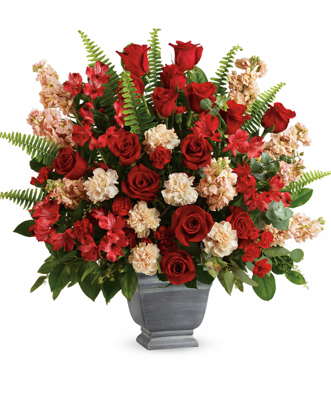 Bold and beautiful, this majestic mix of red roses and fresh greens in a large, stone-inspired pot is a show of strength and support.  