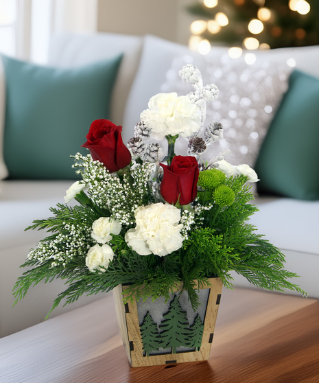 Rustic winter bouquet in wooden box with evergreens, white flowers, berries & frosted pinecones. A natural, woodsy winter accent