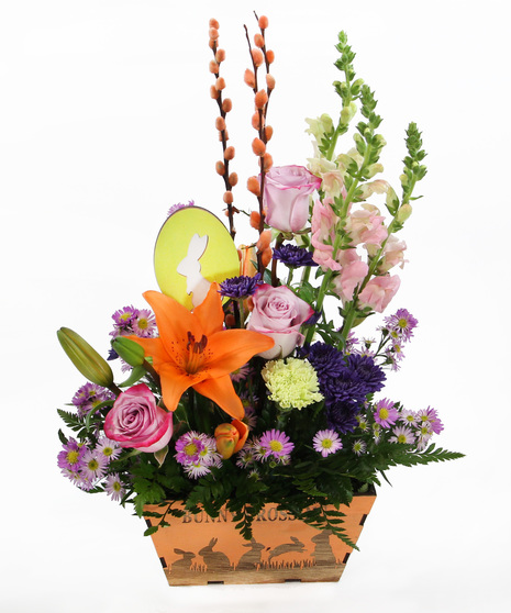 This Easter bouquet features a mix of snapdragons, Asiatic lilies, carnations, and poms, in a wooden Bunny Crossing box with a coordinating bunny pick.