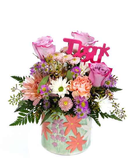 a charming bouquet, arranged in a lovely floral ceramic pot featuring peach disbuds, peach carnations, salmon button poms, white daisies, and delicate purple spring asters