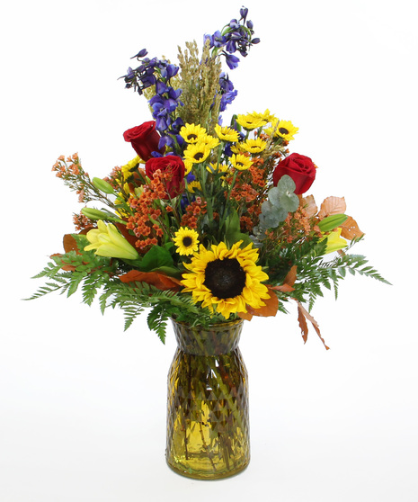 Fascination bouquet with delphinium, sunflowers & lilies in fall-toned vases. Perfect autumn floral gift for any occasion