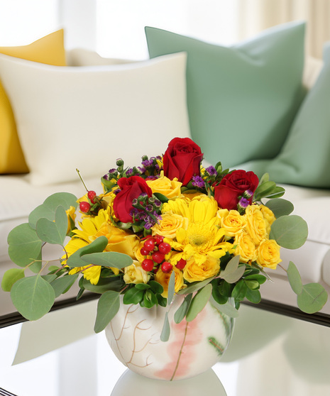 Gerbera daisies, spray roses, and accent blooms in a marble ceramic sphere vase. A colorful and festive bouquet for any celebration