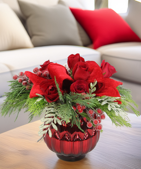 Festive evergreen centerpiece in metallic bowl with red velvet bow, frosted pinecones, icy ferns & berries. Holiday arrangement with optional roses