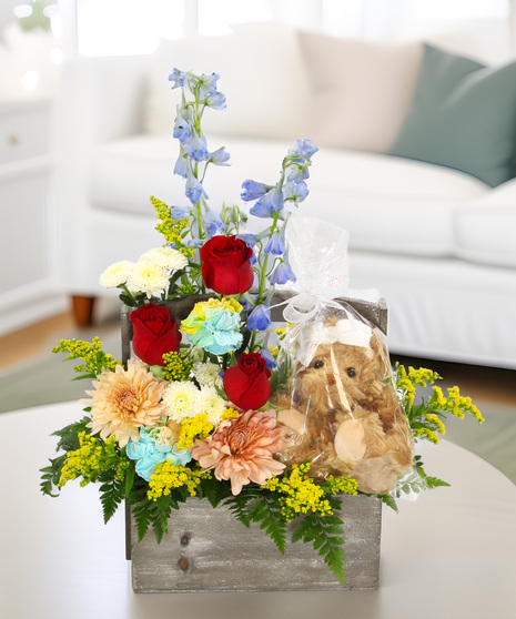 A generous bouquet with a keepsake Bukowski Bear in a wooden handled box. A warm and colorful gift to welcome the newest family member.