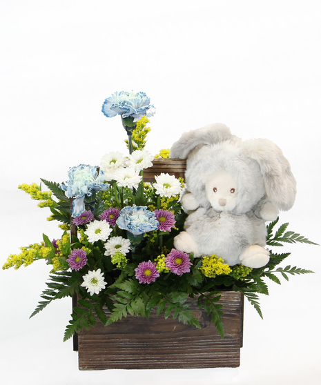 Our New Arrival bouquet is available in pink or blue tones, this design comes nestled in a wooden box, accompanied by a plush bear in a costume. 