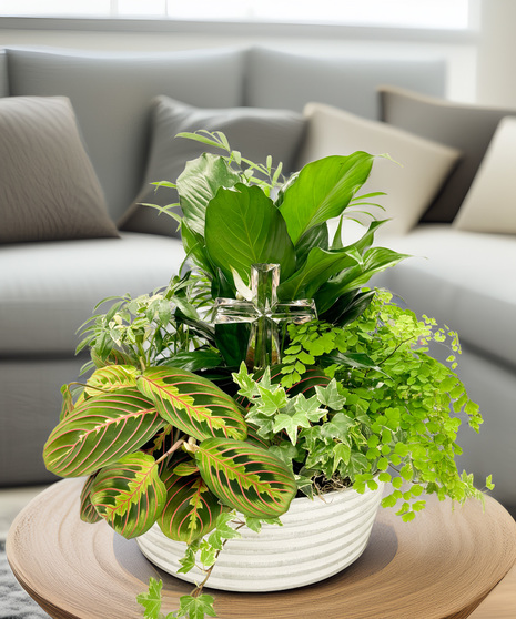 This handcrafted garden promotes hope.  Featuring a peace lily alongside a mix of green and white plants in a burnished silver metal container with a crystal cross figurine.
