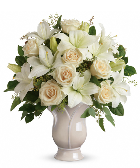 Celebrate a wondrous life with this timeless tribute of pure white lilies and roses, arranged in a graceful tulip-shaped ceramic vase.