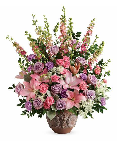 A touching tribute to a beloved woman, this beautiful, soft pink and lavender arrangement is presented in a large antiqued pot for an elegant touch.