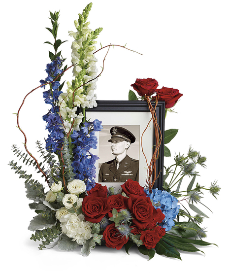 Honor their memory with a beautiful display bouquet designed to surround a photo, its patriotic mix of blue hydrangea with red and white roses is a respectful tribute.