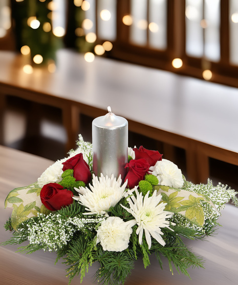 All-white holiday centerpiece with silver pillar candle, spider mums, carnations & glittered berries. Elegant arrangement with optional roses.